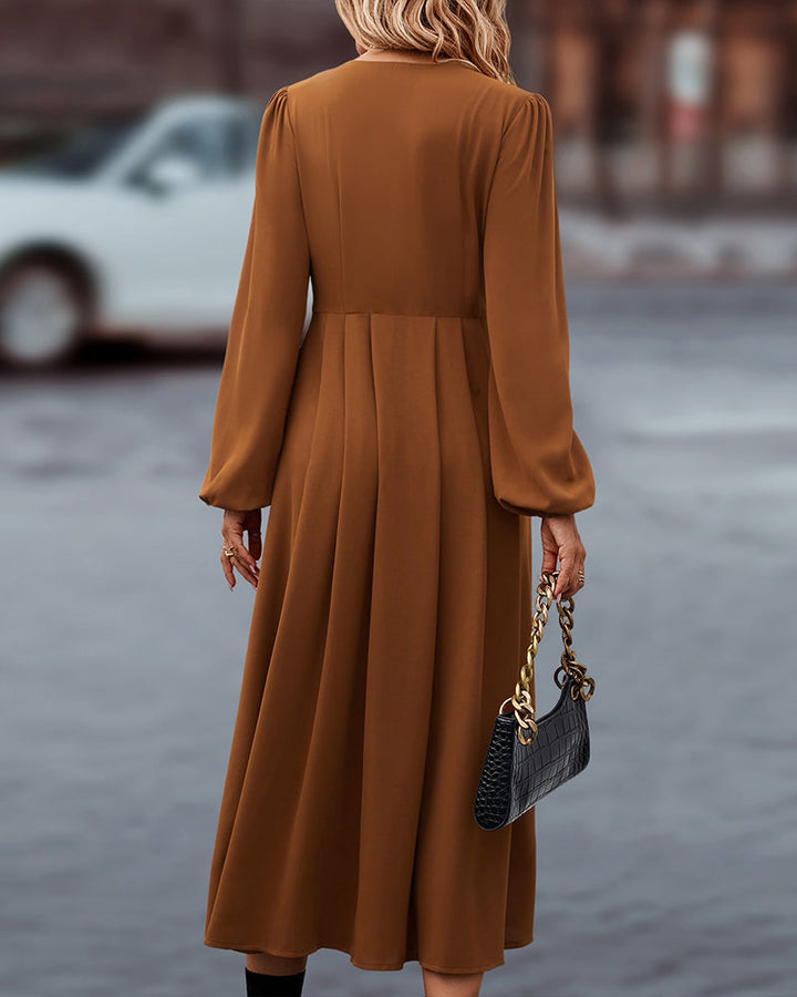 Elegante midi-jurk met knoopsluiting en lange ballonmouwen, ideaal voor een stijlvolle kijk