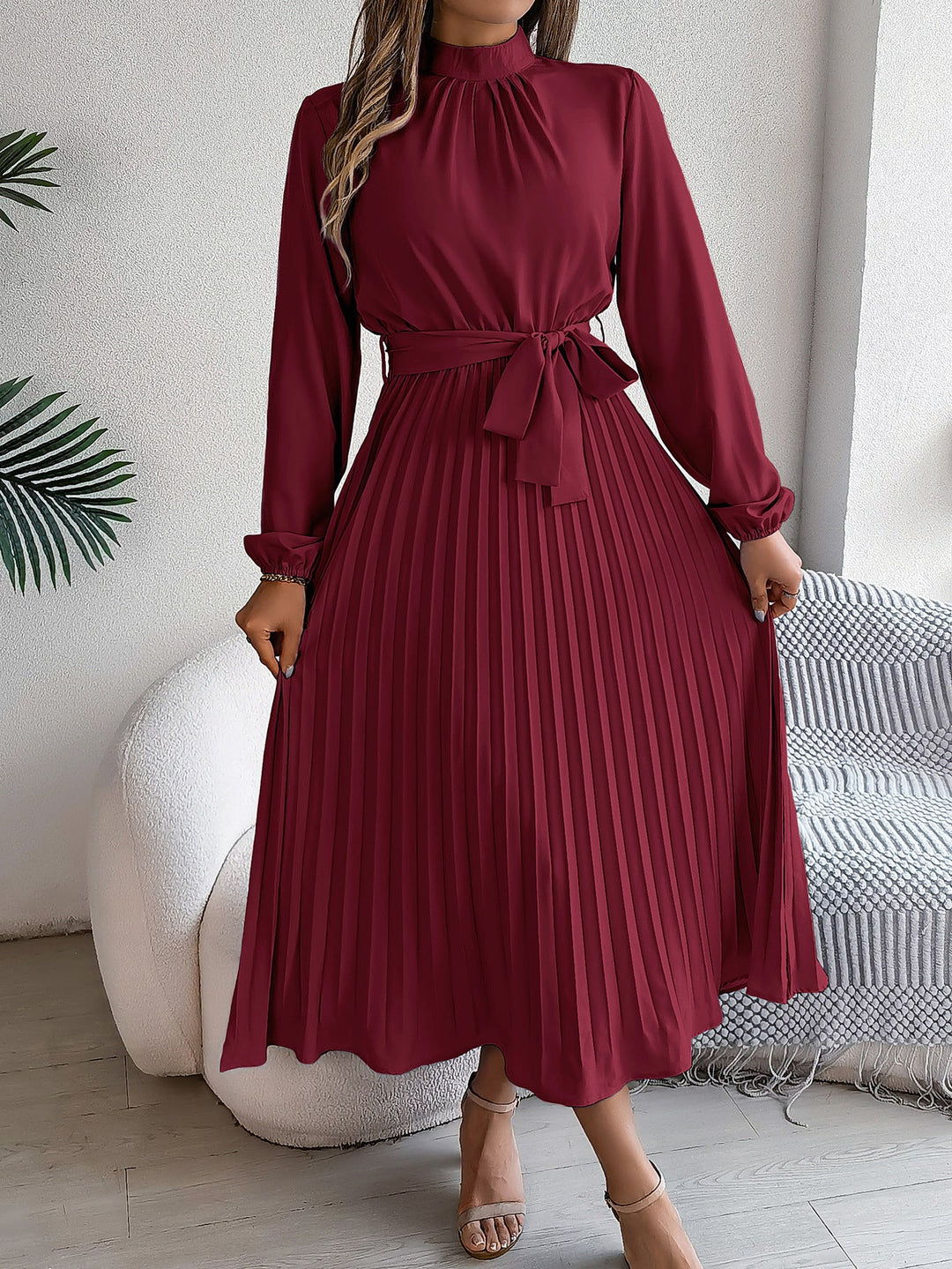 Elegante damesjurk met opstaande kraag lange mouwen en geplooide rok