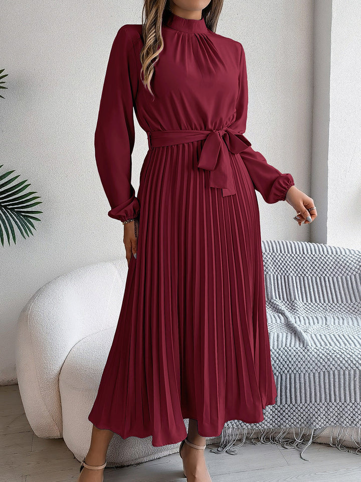 Elegante damesjurk met opstaande kraag lange mouwen en geplooide rok