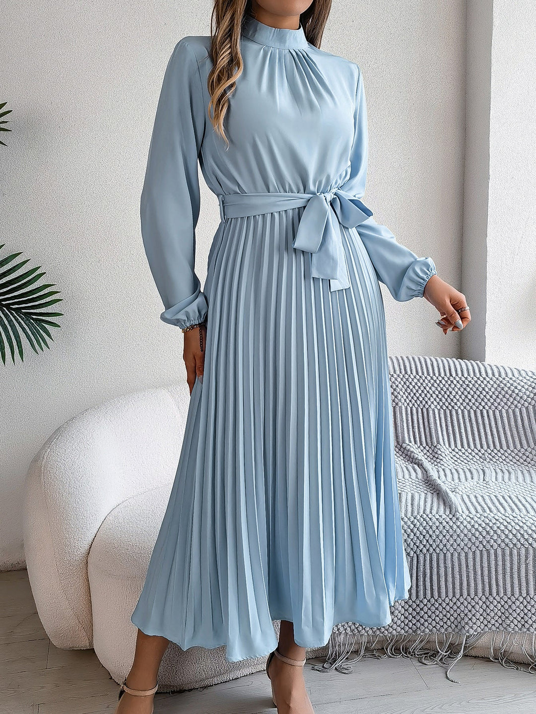 Elegante damesjurk met opstaande kraag lange mouwen en geplooide rok