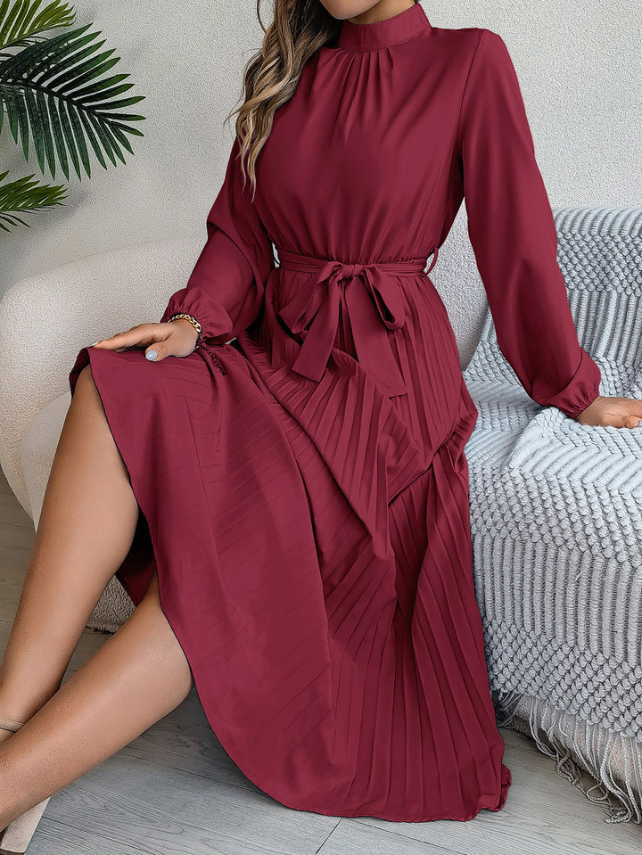 Elegante damesjurk met opstaande kraag lange mouwen en geplooide rok
